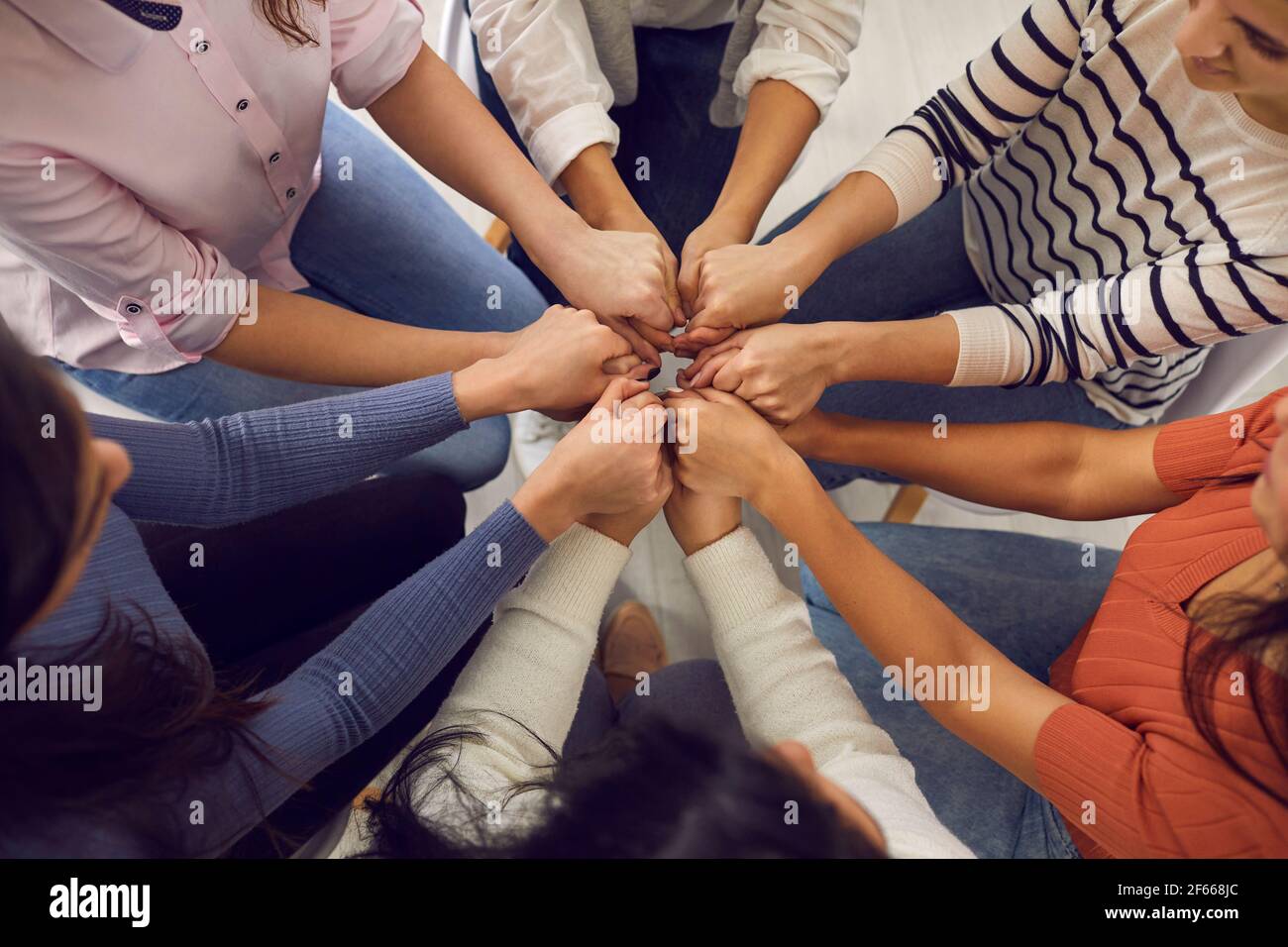 Women's hands holding each other in group therapy or in a session with a motivational trainer. Stock Photo