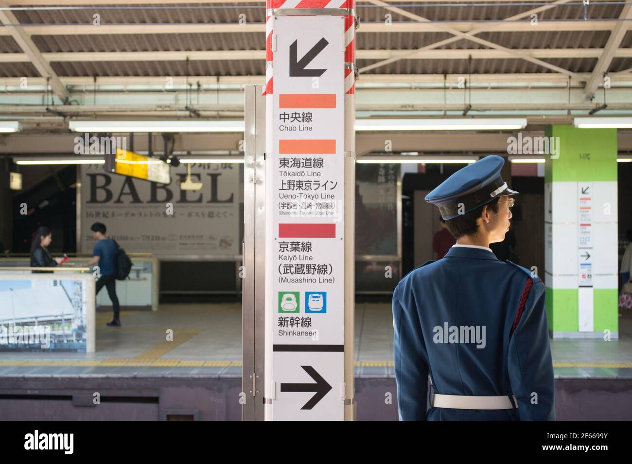 Tokyo, Japan - Japanese train conductor on his duty on the platform. Railway staff watching the train coming. Stock Photo