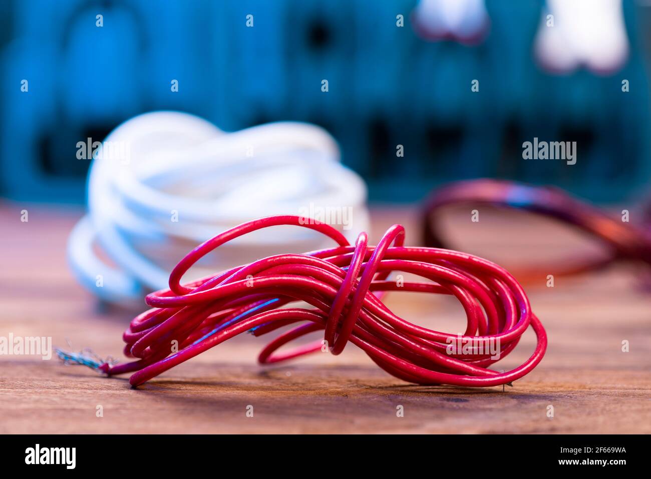 Red electrical cable close-up on the electrician's desk. Stock Photo