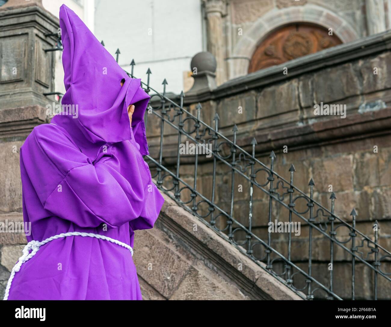 Portrait of a covered Cucurucho penitent with purple cape during the Easter procession in front of the San Francisco convent in Quito, Ecuador. Stock Photo