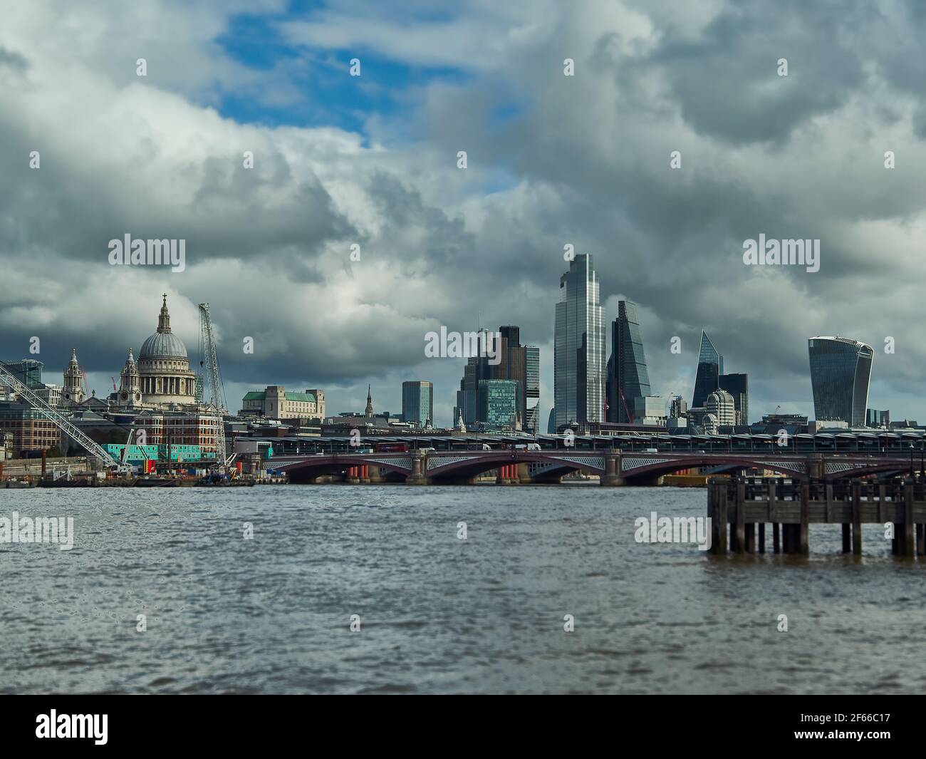 The City of London from the South Bank across a steely Thames, taking in the modern skyscrapers as well as the more traditional St. Paul’s Cathedral. Stock Photo