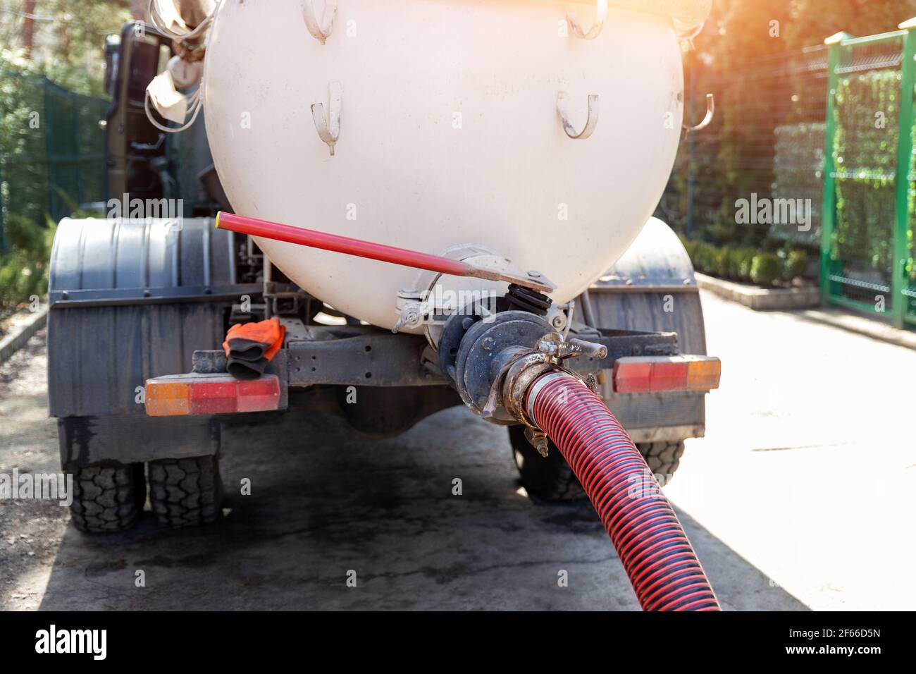 Closeup pipe hose of sewage truck car engine emptying home sewerage