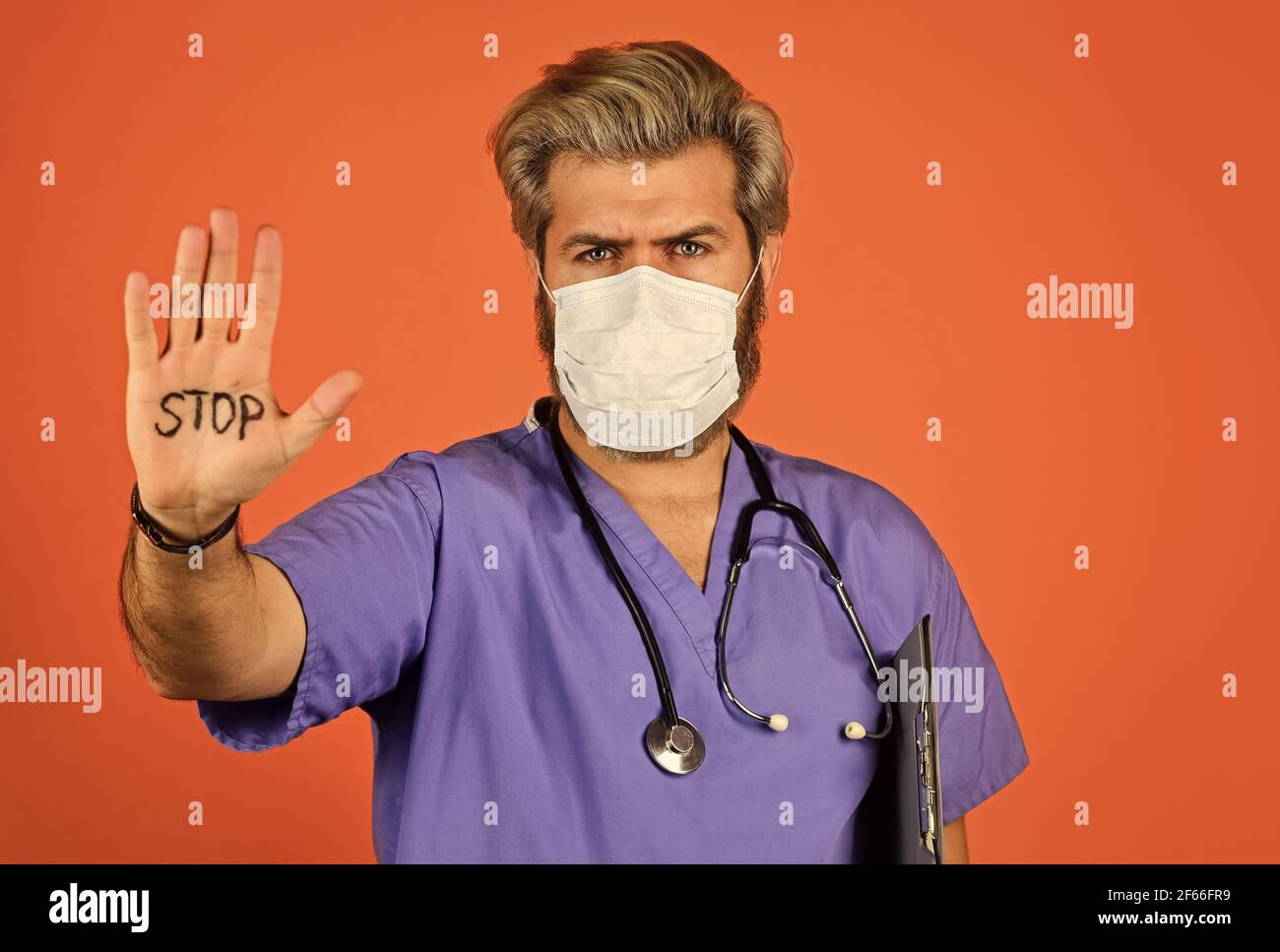 Epidemic threshold. Man in medical lab. Protective mask. Open palm stop gesture. Danger zone. Stop epidemic. Virus concept. Epidemic infection Stock Photo