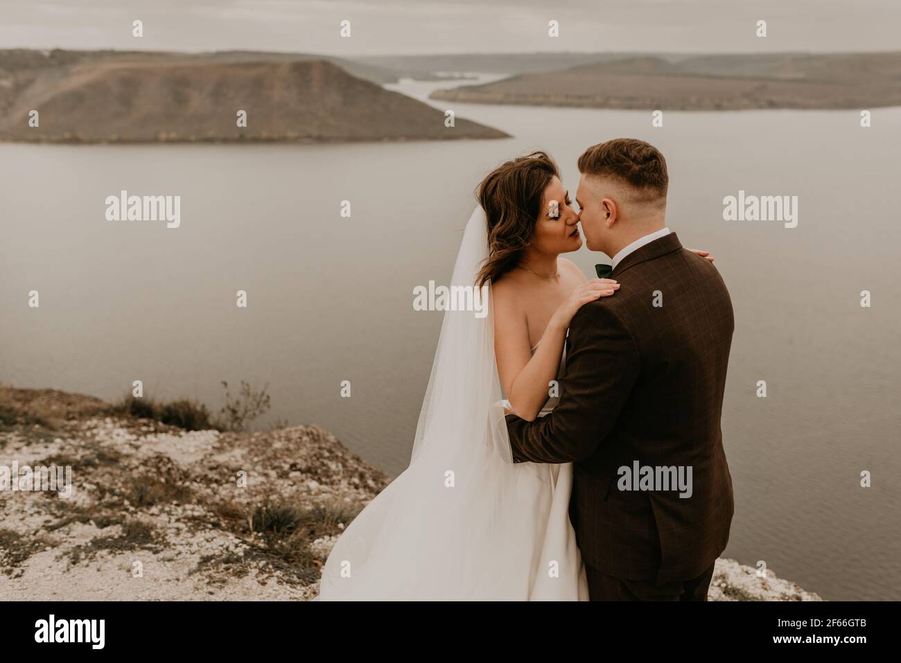 loving couple wedding newlyweds outdoor. bride in white dress long veil and groom in suit walk in summer fall on mountain above river. sunrise. man an Stock Photo Alamy