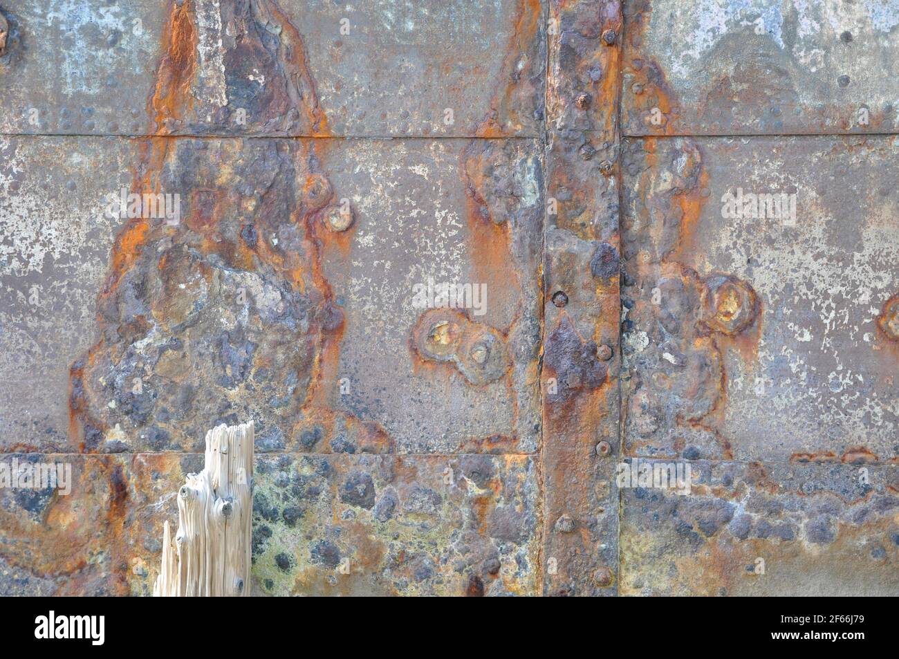 Rusty ships plates, now used to reinforce the river bank.Bright coloured in the sun.Hayle. Cornwall. UK. Stock Photo