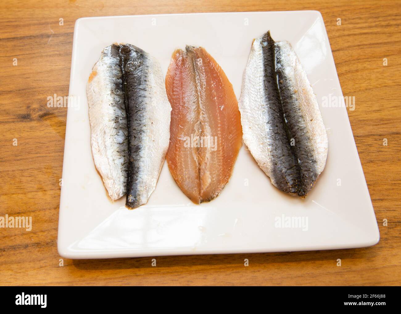 Raw North East Atlantic Butterfly Sardines on a plate before being cooked Stock Photo