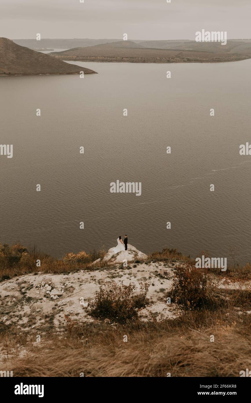 a wedding couple in love, groom and the bride in dress veil stand on ...