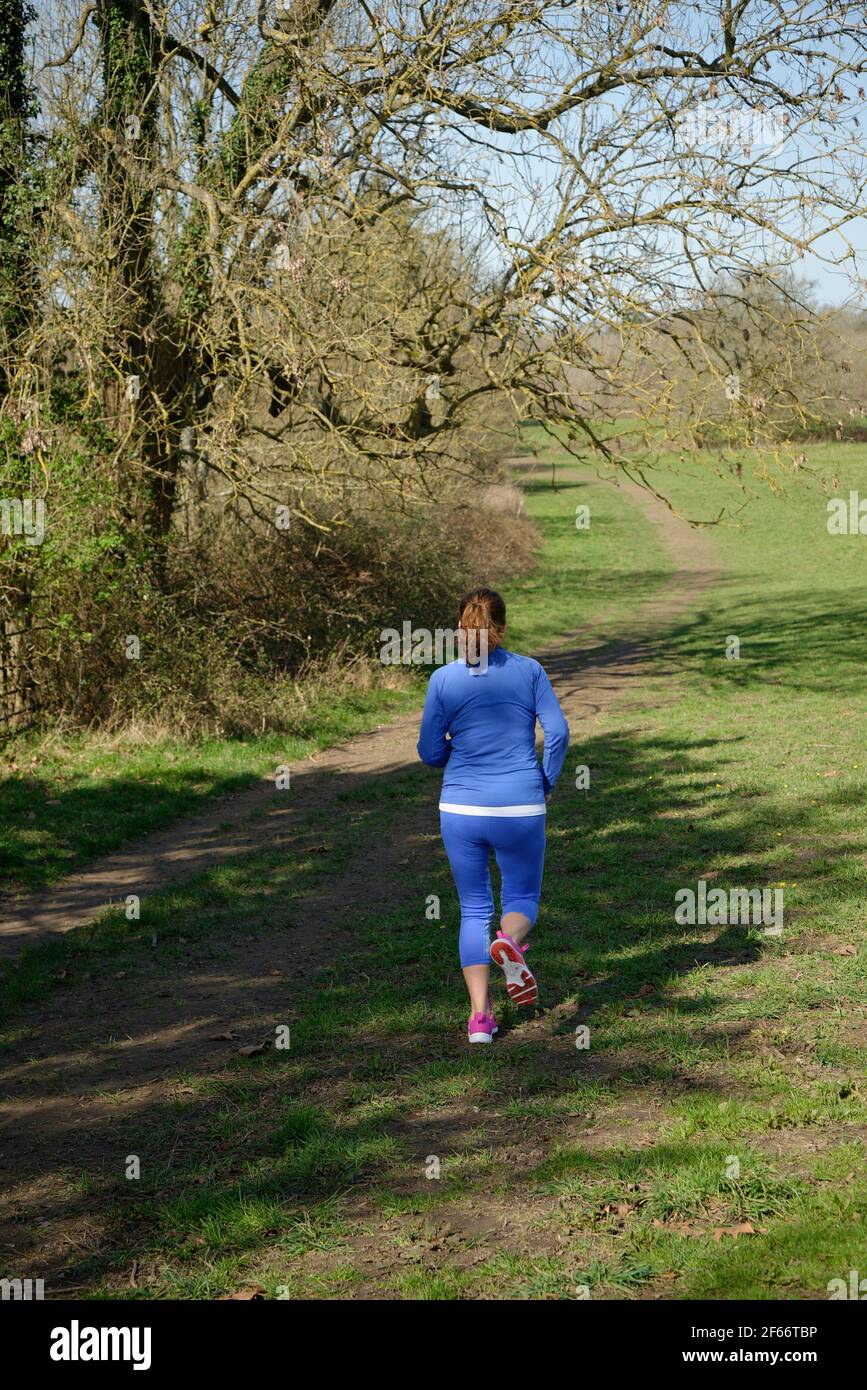 A middle aged woman taking exercise. A woman running. Stock Photo
