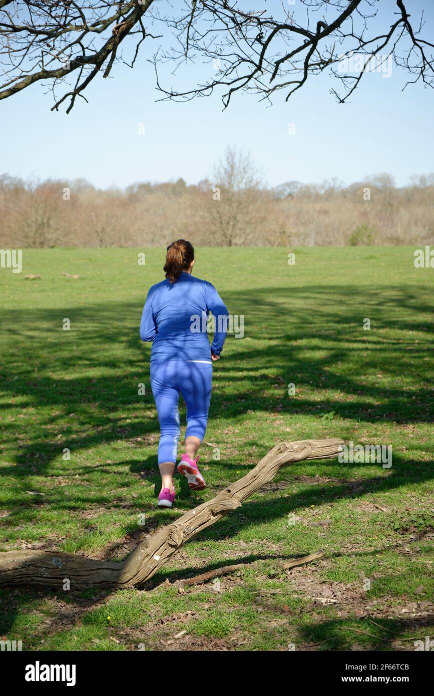 A middle aged woman taking exercise. A woman running. Stock Photo