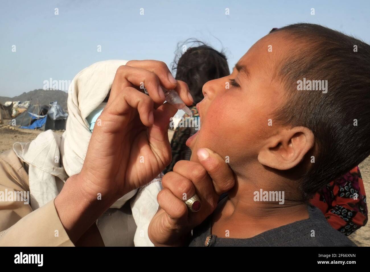 Kandahar, Afghanistan. 30th Mar, 2021. A health worker gives a polio vaccine to a child during an anti-polio vaccination campaign in Panjwai district of Kandahar province, southern Afghanistan, March 30, 2021. On Monday, the Afghan Public Health Ministry launched a nationwide campaign to give polio vaccination doses to 9.6 million children under the age of five. Credit: Sanaullah Seiam/Xinhua/Alamy Live News Stock Photo
