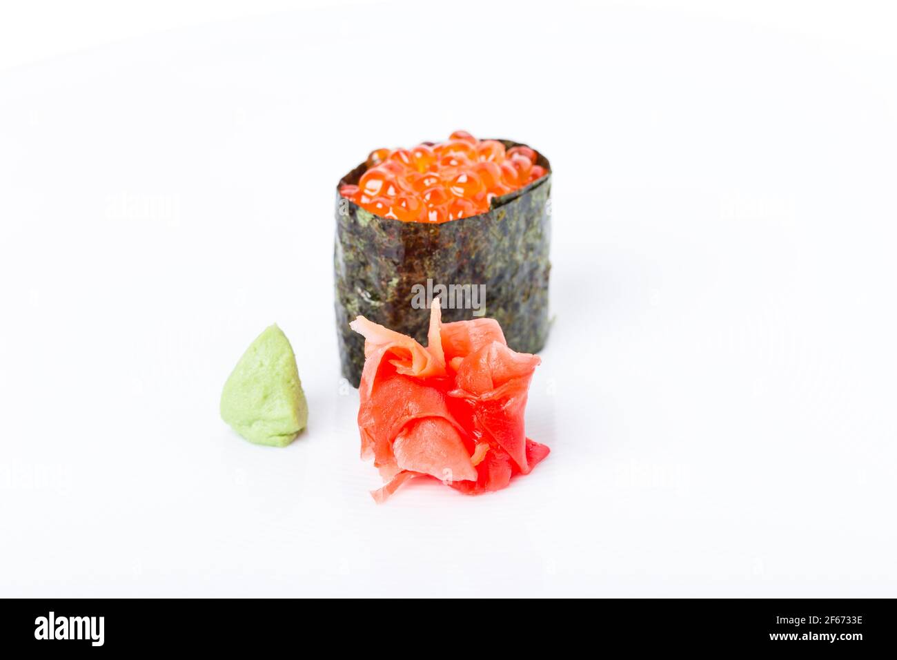 Gunkan sushi stuffed with red salmon caviar. Served with heap of ginger and wasabi. Selective focus on heap of ginger. Macro. Can be used as a whole b Stock Photo