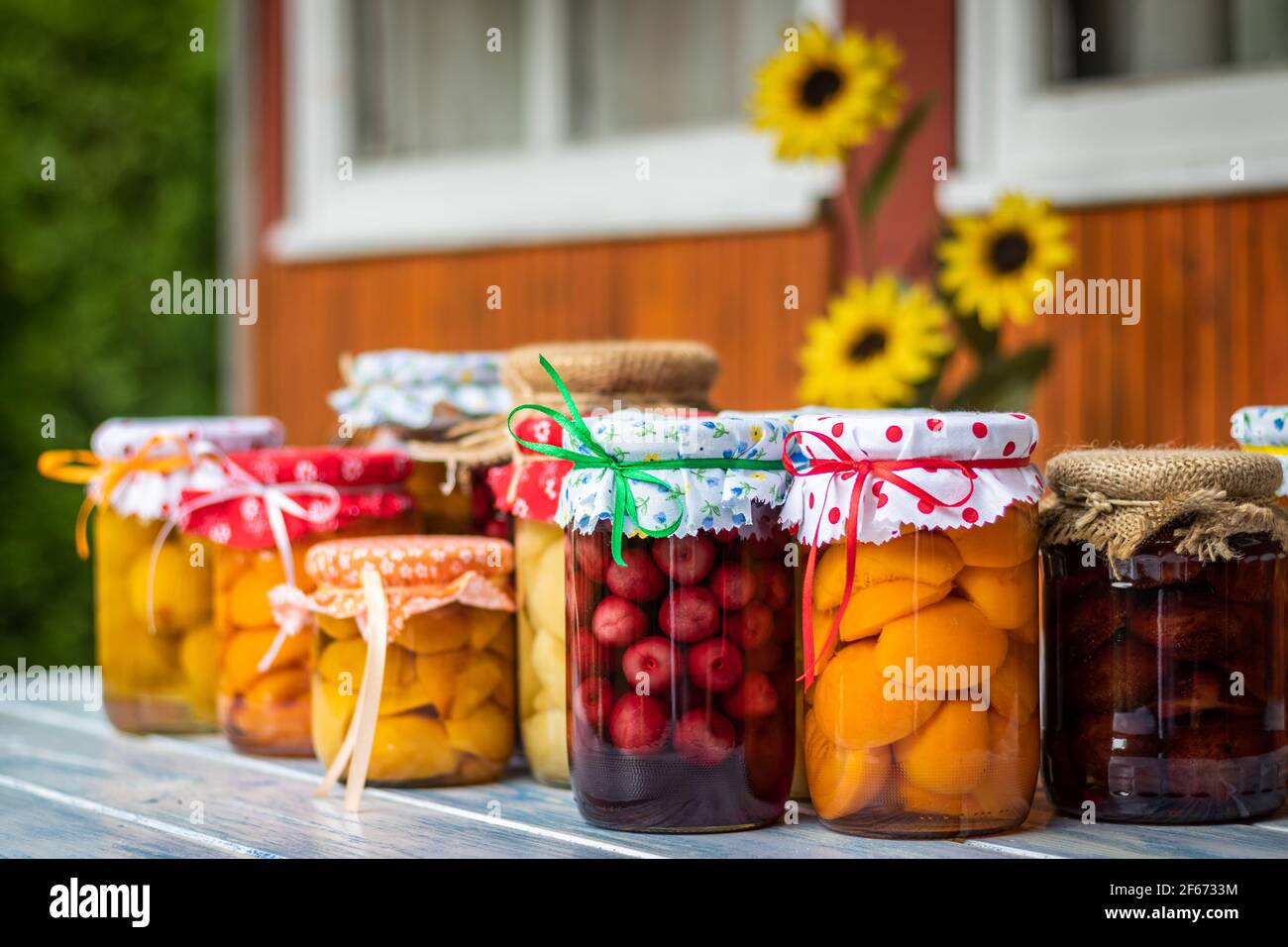 Variety of diferent fruit compote in jar. Homemade preserved food on table. Peach, apricot, cherry, apple, pear and plum compotes Stock Photo