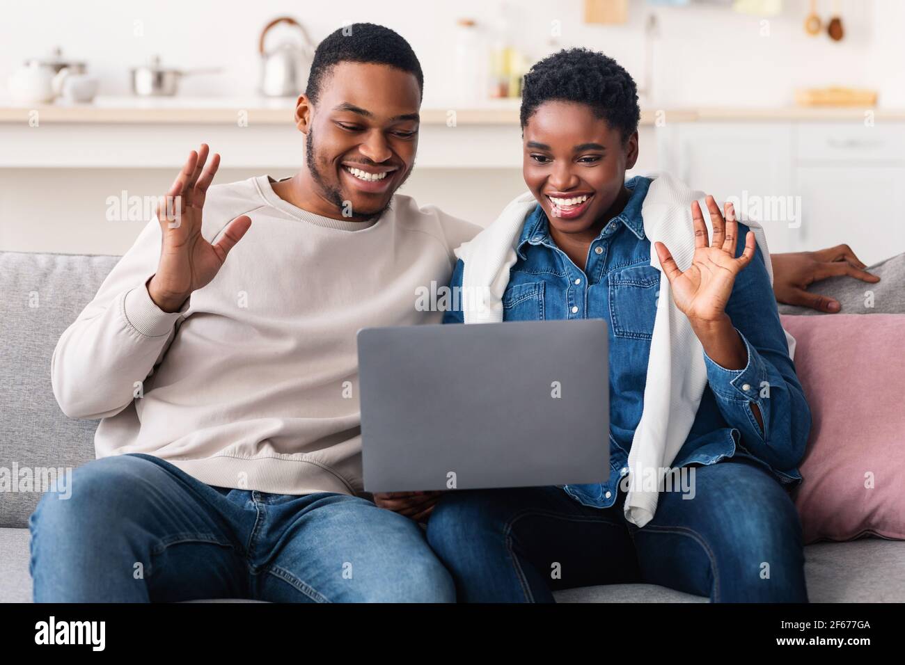 Black couple having videocall using laptop waving hands Stock Photo