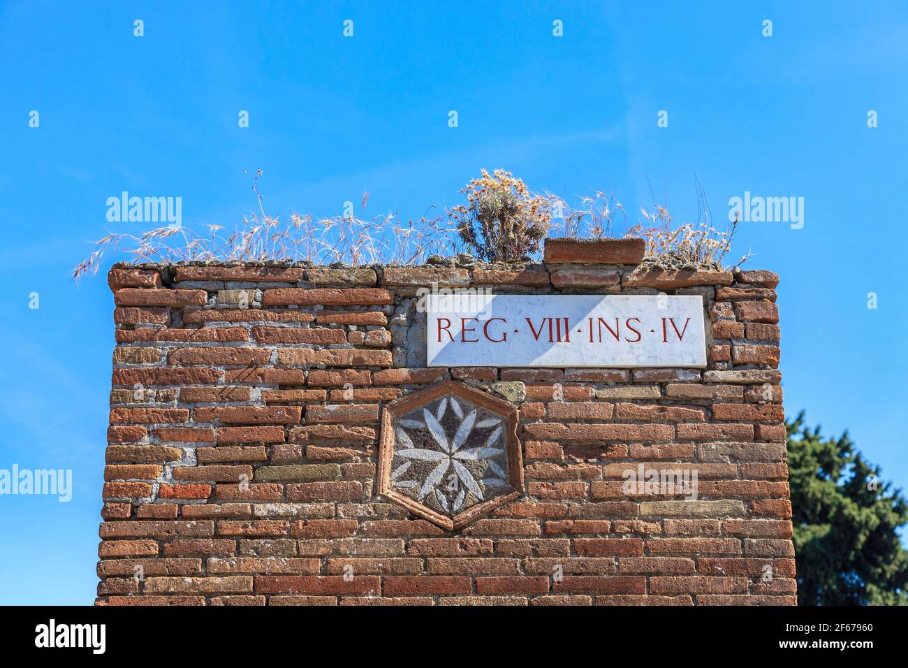 A region street sign and mosaic artwork in the Roman city of Pompeii, Italy Stock Photo
