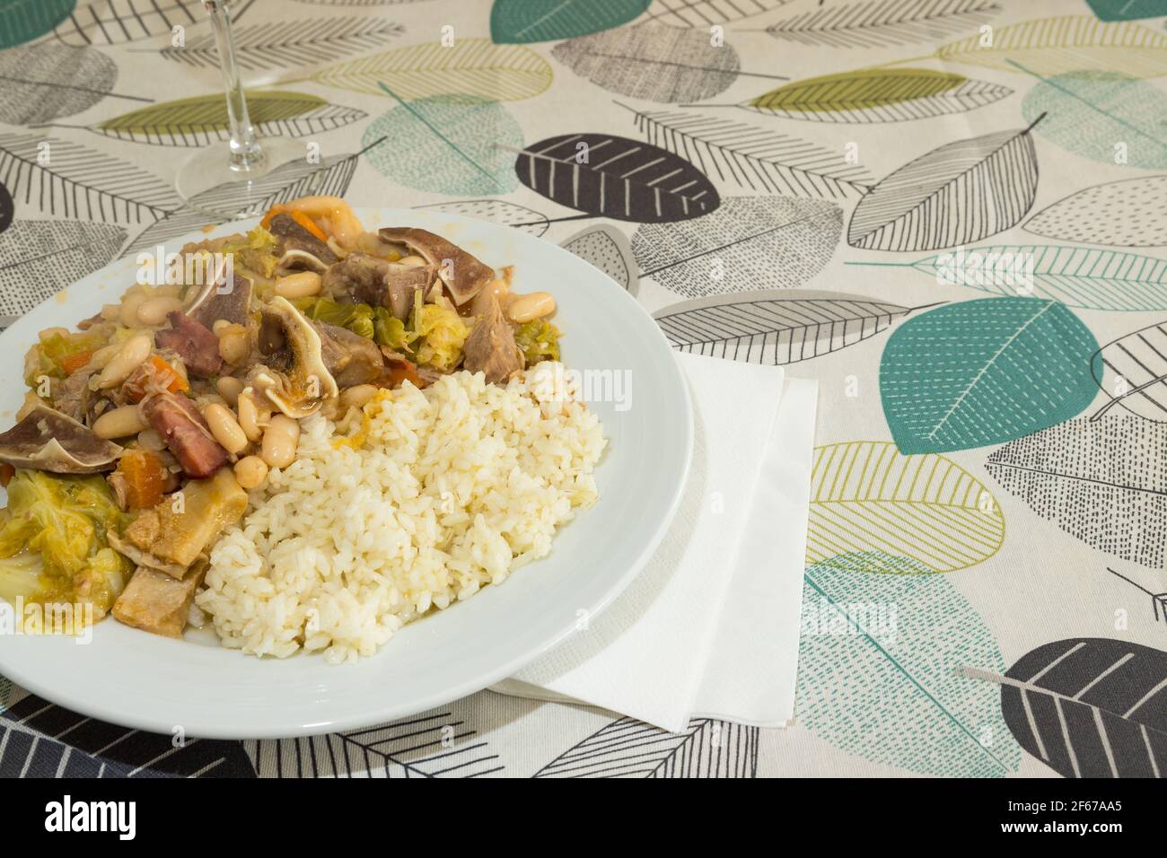 Homemade 'Feijoada' ready to eat. It is a typical portuguese dish made of boiled white beans, vegetables, beef and pork meats served with rice. Stock Photo