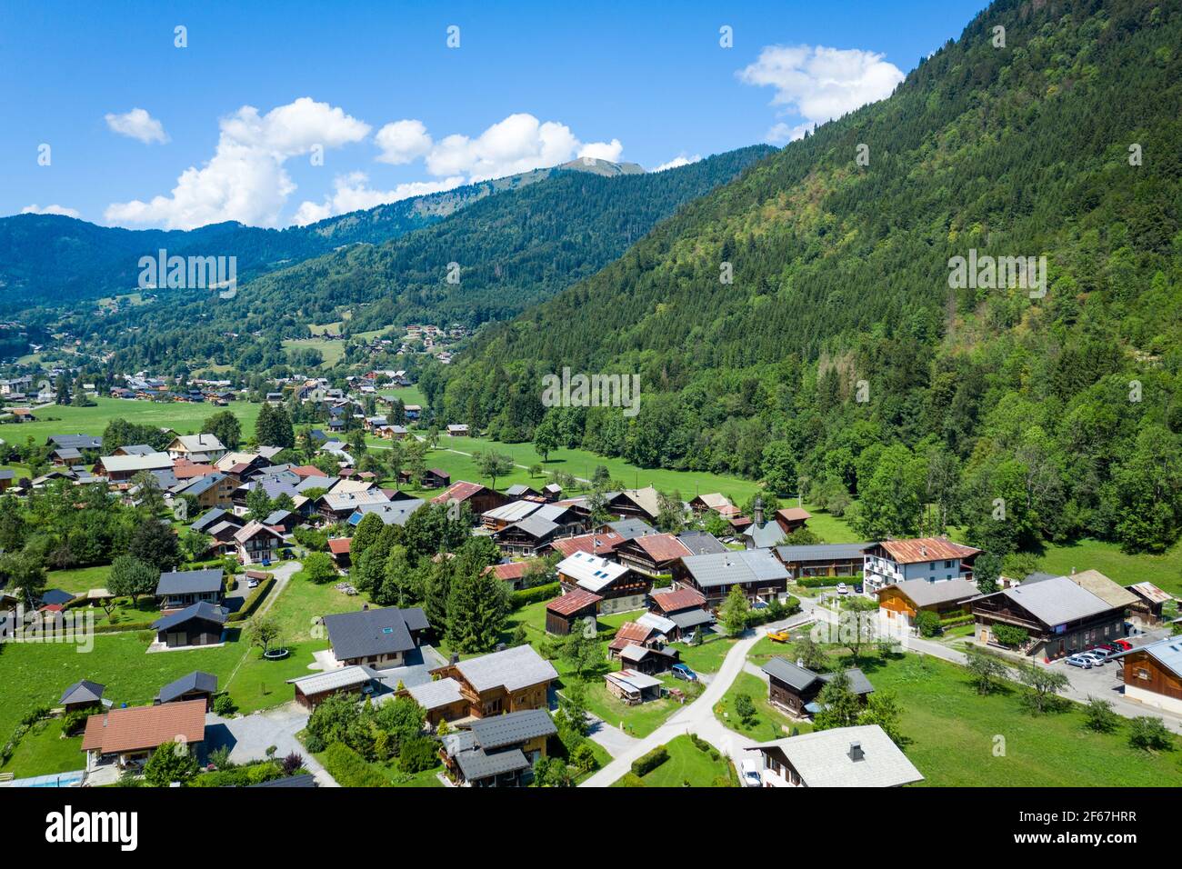 Drone view of mountain village houses scattered across foot of mountains. Beauty of Giffre mountains region, France. Stock Photo