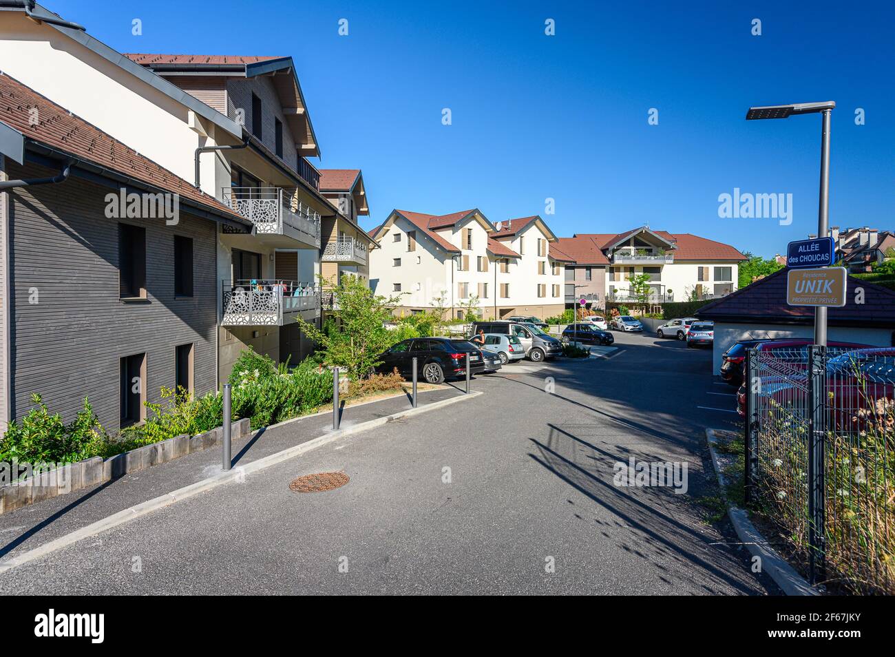 Entrance to complex of houses with parking and flower gardens. Ground
