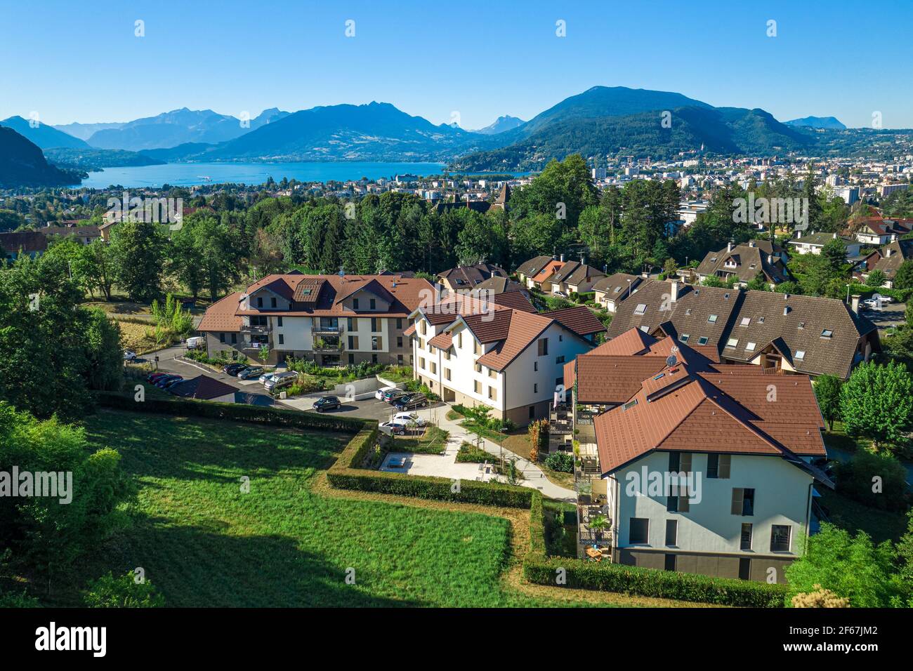 Complex of houses with mountains and large lake in distance. Aerial