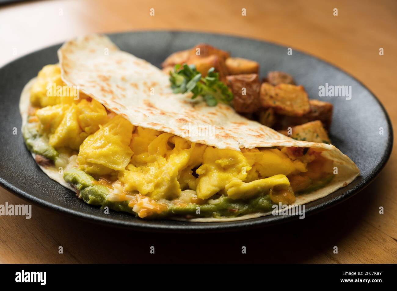 Huevos Rancheros. Three scrambled eggs in a flour tortilla with refried
