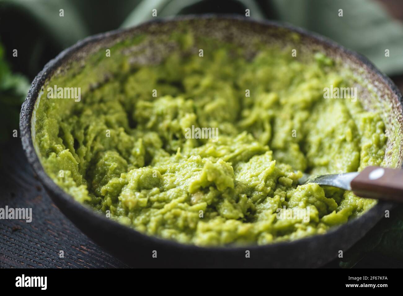 Mashed avocado in a bowl. Vegan food Stock Photo