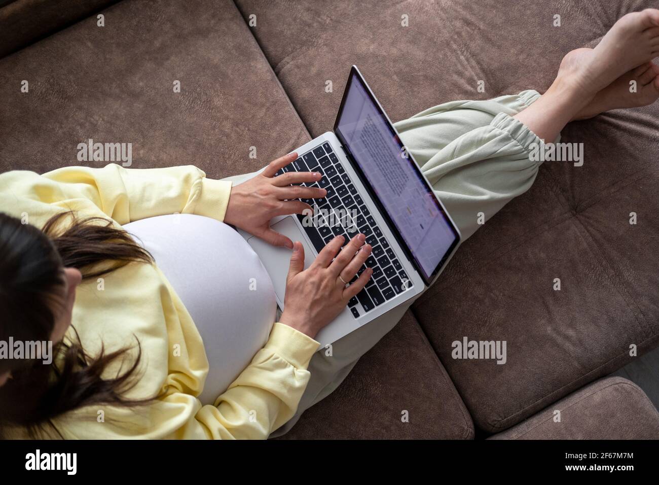 Attractive pregnant young lady working remotely online from home. Close