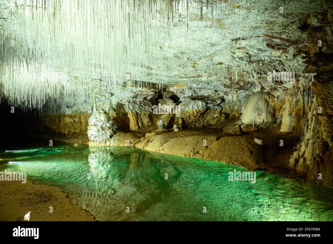 Emerald green water in underground river illuminated by spotlights. Cave  with white stalactite decoration. Vercors mountains, France Stock Photo -  Alamy