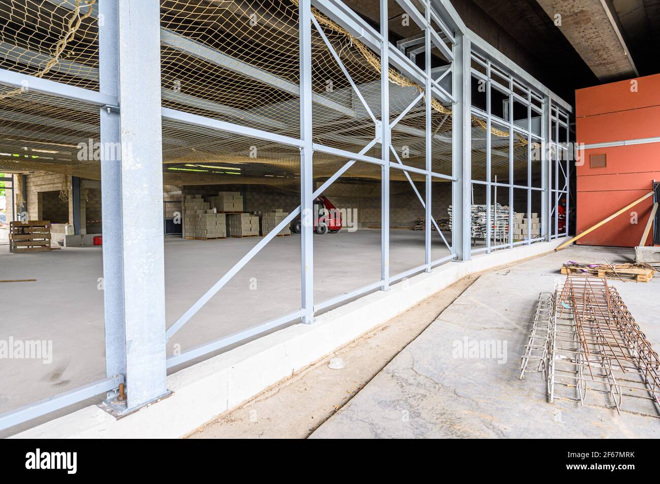 Tall steel construction of glass wall under highway bridge. Transport infrastructure
