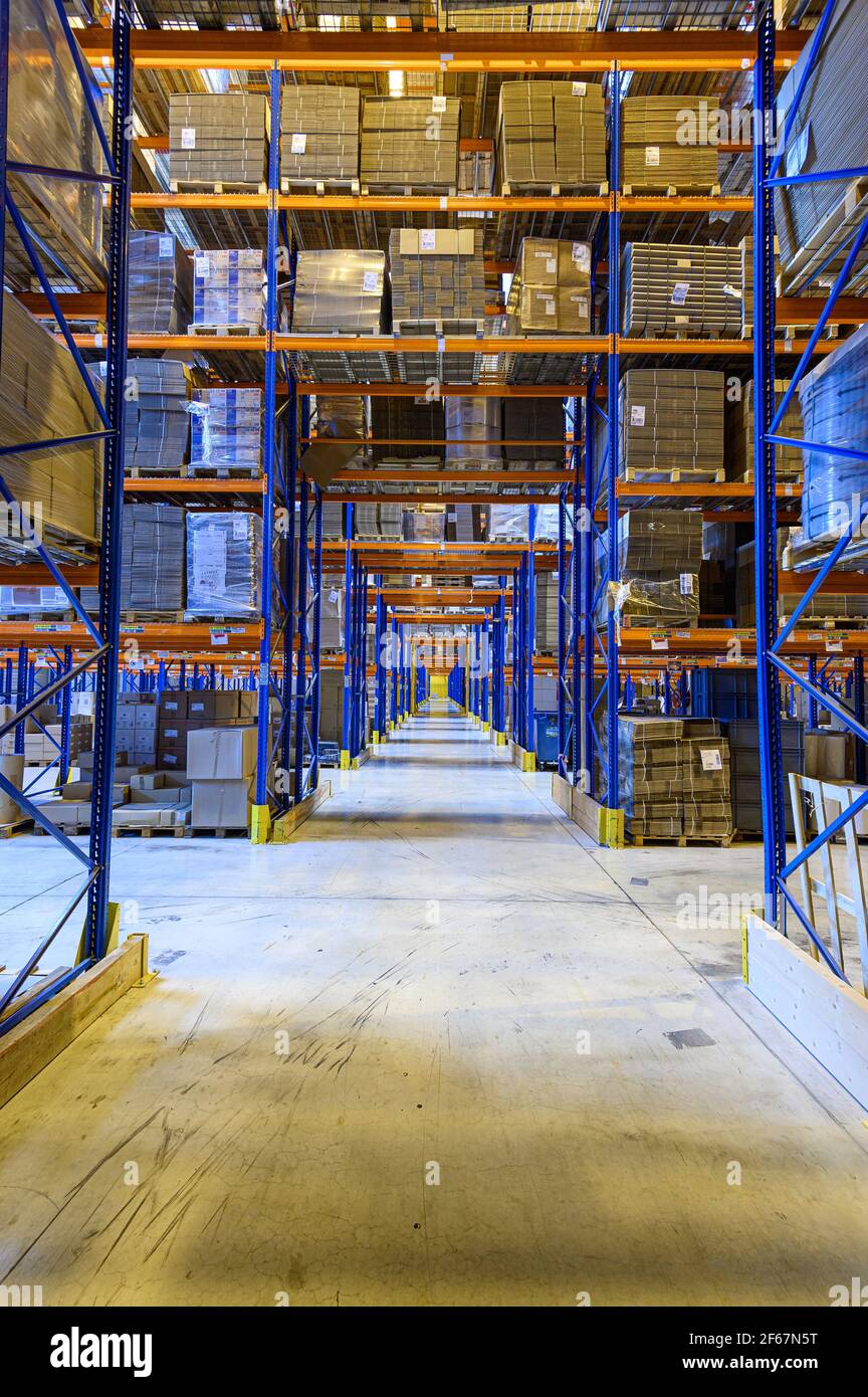 Forklift cross bridge aisle in racking system in distribution centre warehouse. Storing goods on palettes. Transport and logistics. Stock Photo