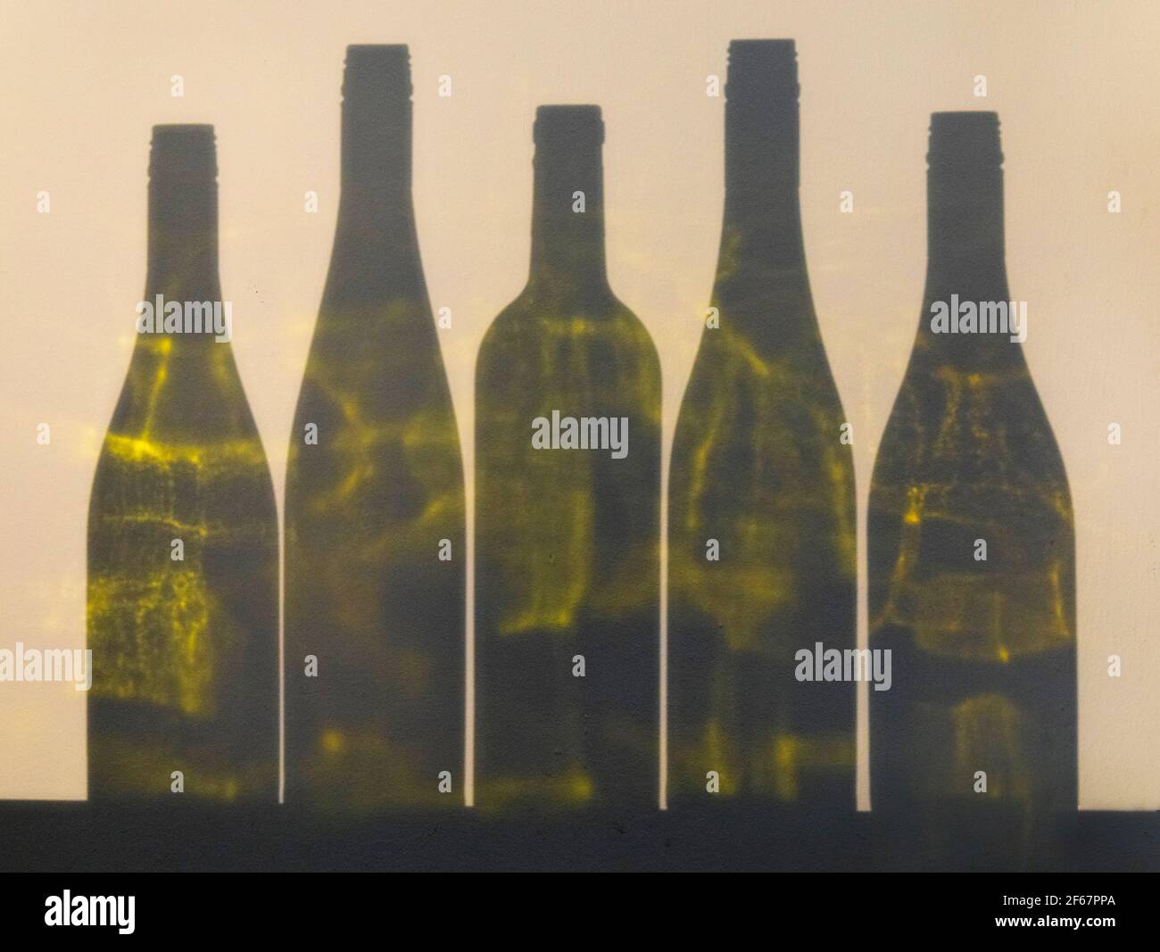 Coloured shadows of empty wine bottles on a wall Stock Photo
