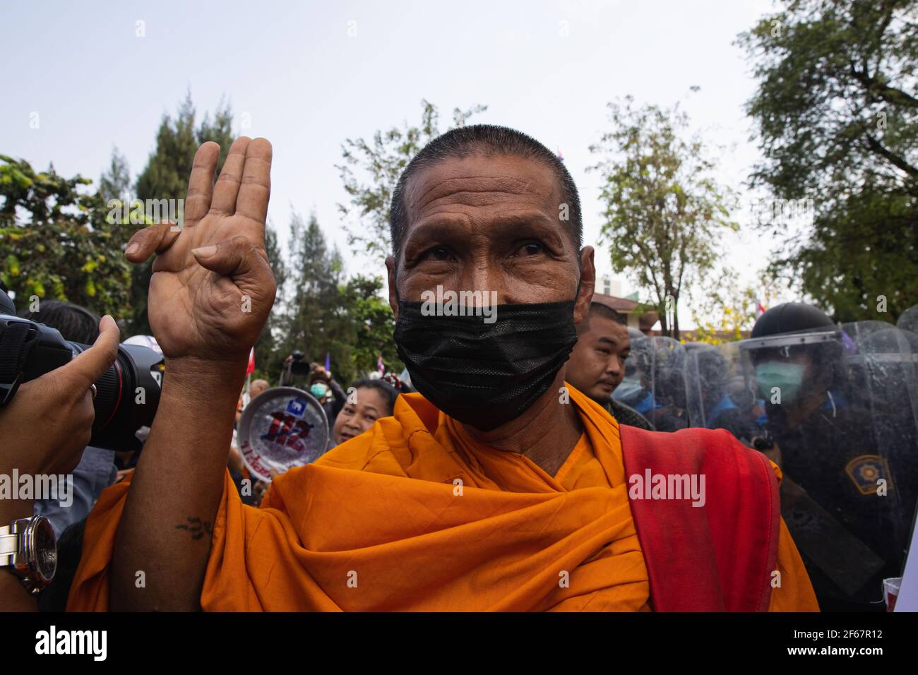 Monk makes a three finger salute during the demonstration. Pro-democracy protesters' 'Walk through sky' gathering at the government house demonstrate after they got released from  Metropolitan Police Bureau that rounded them up in two separate operations at dawn and dusk on Sunday. The Protesters demand the resignation of Prime Minister Prayut Chan-ocha, constitutional reform, and abolition of lese majeste law. (Photo by Varuth Pongsapipatt / SOPA Image/Sipa USA) Stock Photo