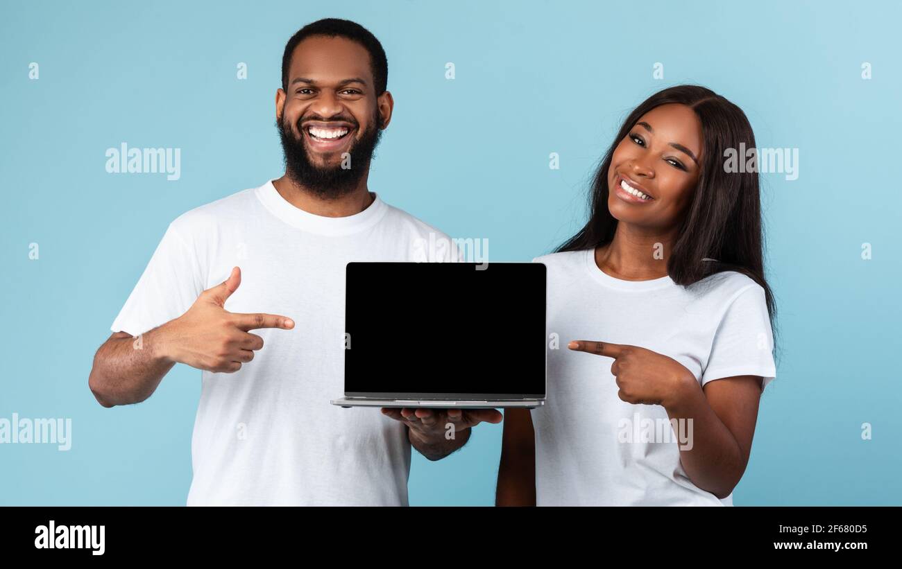 Black couple showing blank empty laptop screen for mock up Stock Photo ...