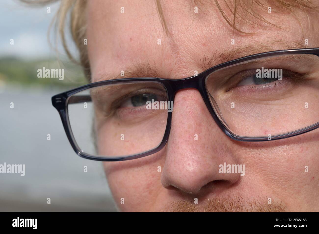 Closeup of Young Man in Glasses Looking at the Camera Stock Photo