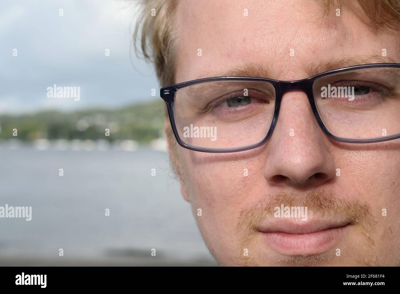 Handsome Young Man Wearing Glasses Smiling at the Camera Stock Photo