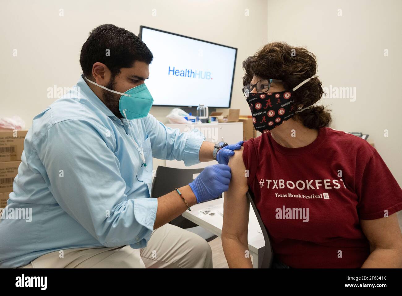 Austin, Texas March 30, 2021:  JANIS DAEMMRICH (r), 65, gets her second shot of Pfizer's COVID-19 vaccine at a local pharmacy, three weeks after the first in the same location. Texas is reporting larger shipments of vaccinations and 1 in 6 eligible Texans are fully vaccinated, around 16%. Stock Photo