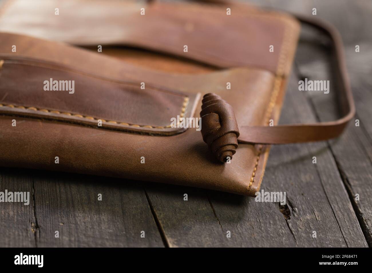 Brown fashion tobacco pouch leather on wood background. Craft product handmade. Stock Photo