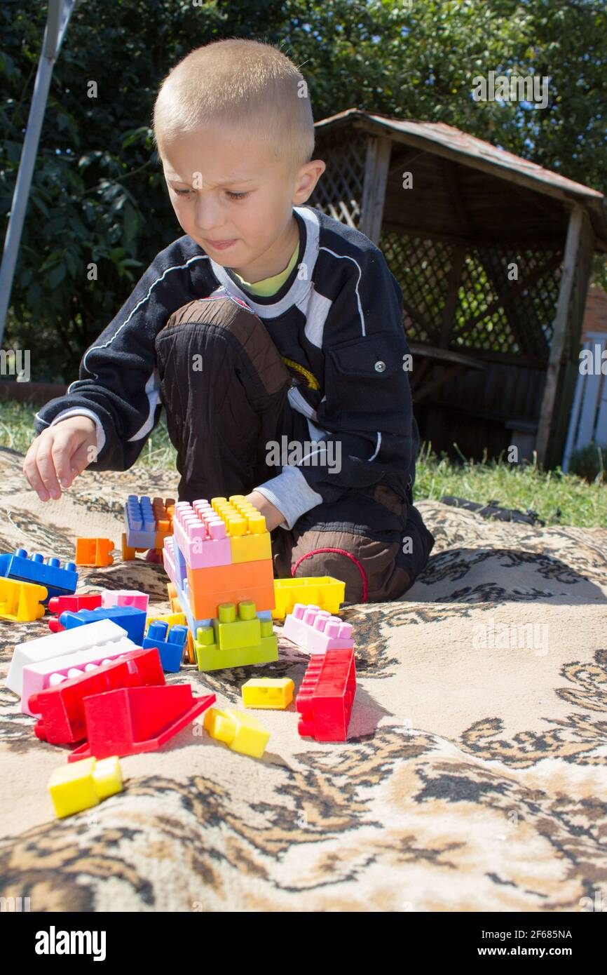 Boy thinks making designer toys in the yard Stock Photo