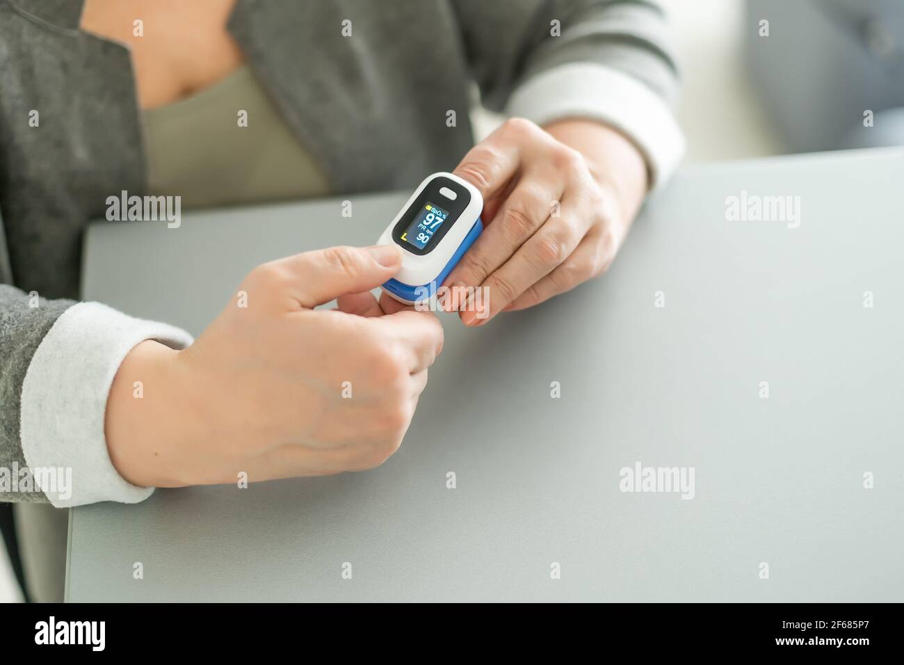 Old lady measuring her oxygen saturation with a pulse oximeter. Health ...