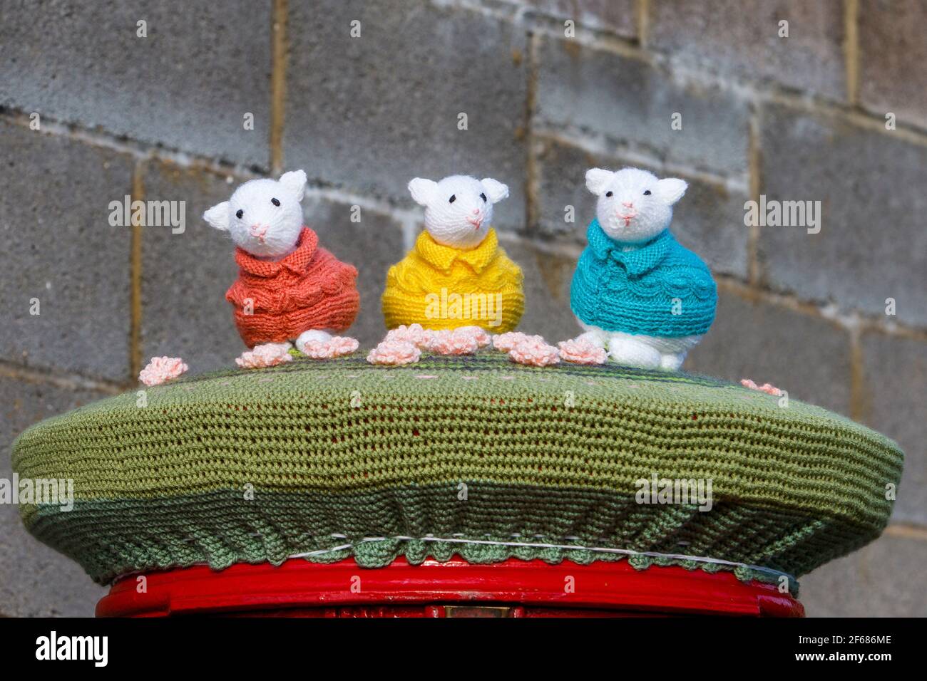 Chippenham, Wiltshire, UK, 30th March, 2021. Three colourful knitted easter animals are pictured on top of a Royal Mail post box after yarn bombers had paid a visit to the street in Chippenham, Wiltshire Credit: Lynchpics/Alamy Live News Stock Photo