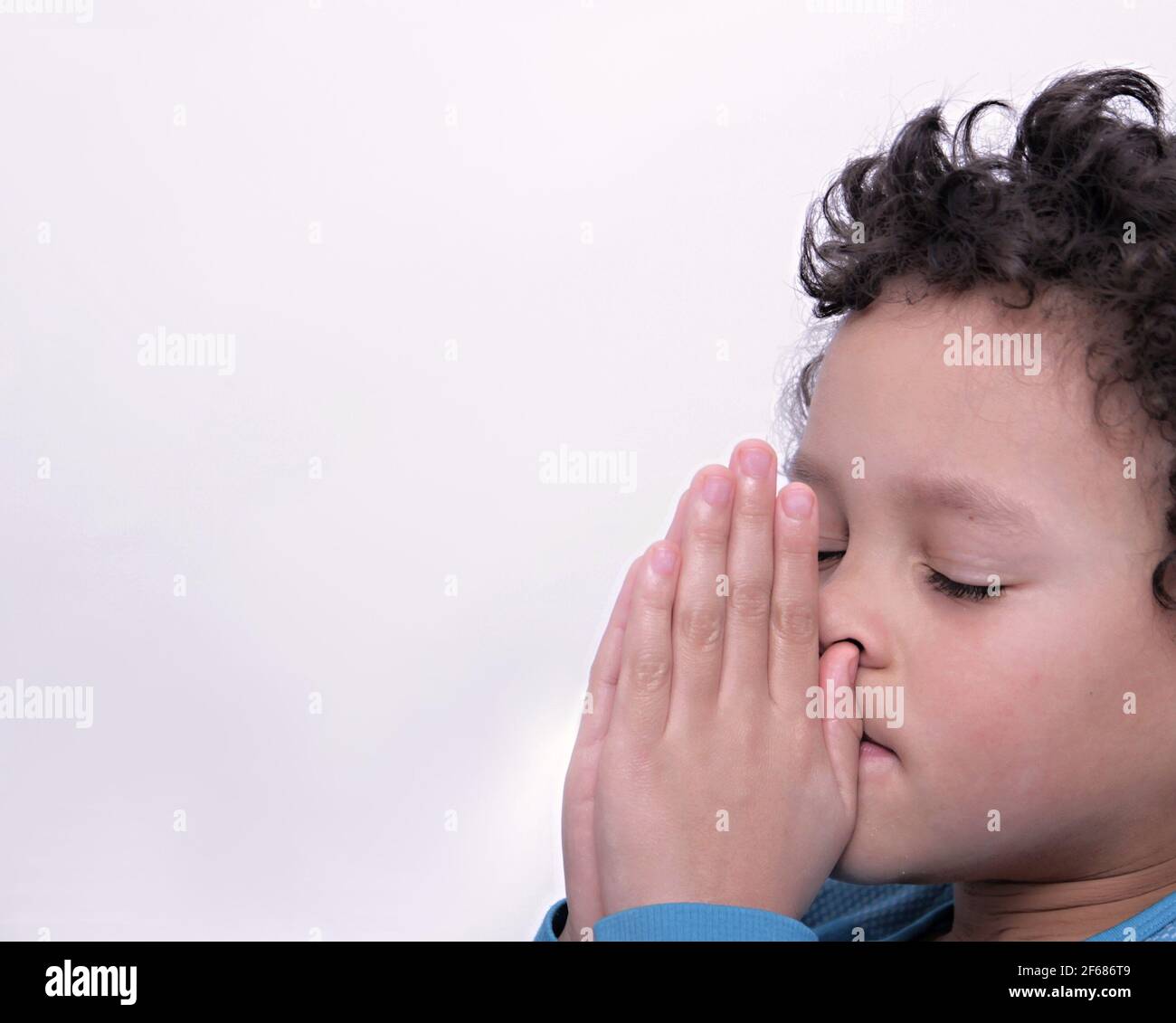 boy praying to God with hands together stock photo Stock Photo