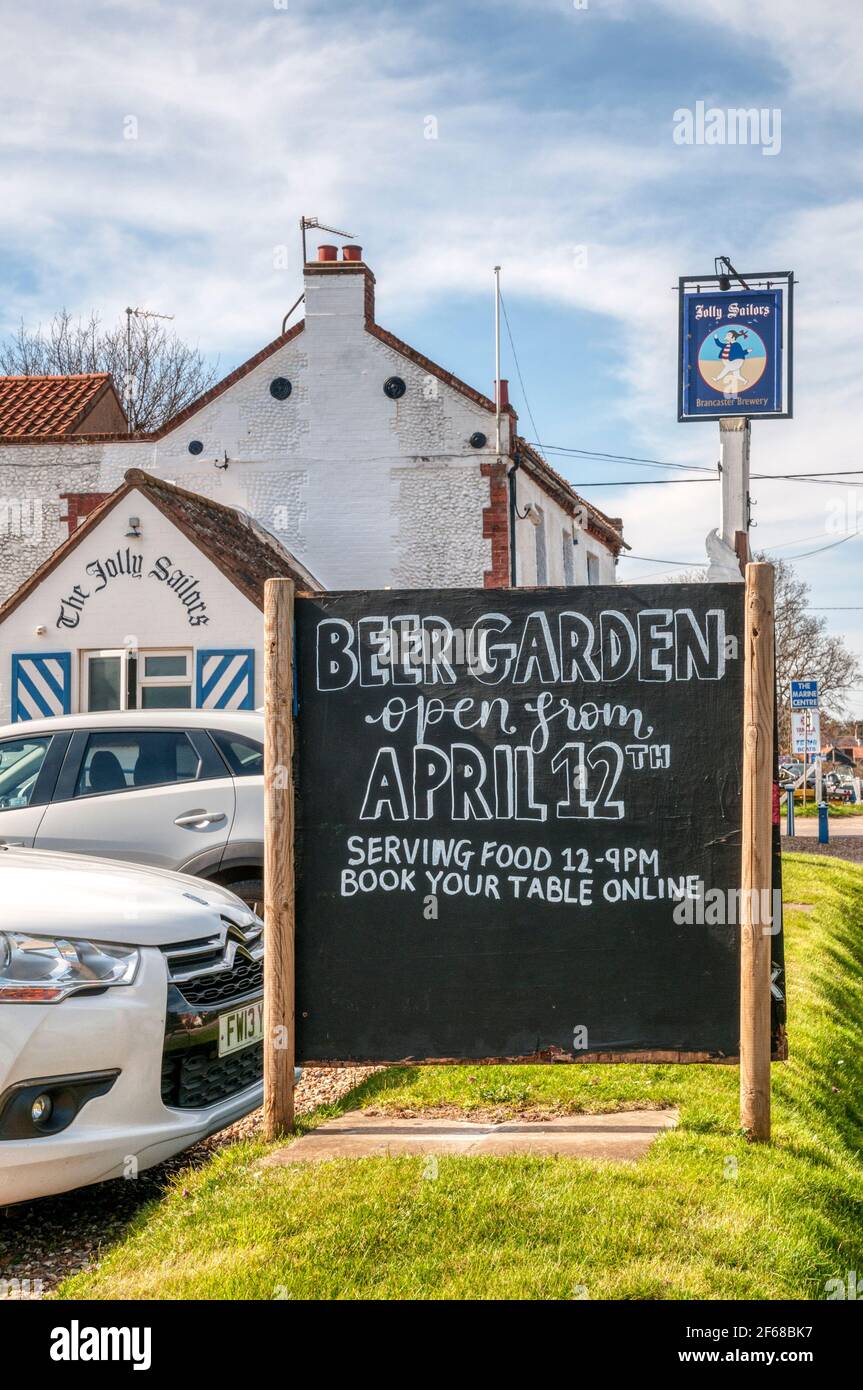 After the 2021 coronavirus COVID-19 lockdown, the Jolly Sailors pub on the North Norfolk coast advertises a beer garden open from April 12th. Stock Photo