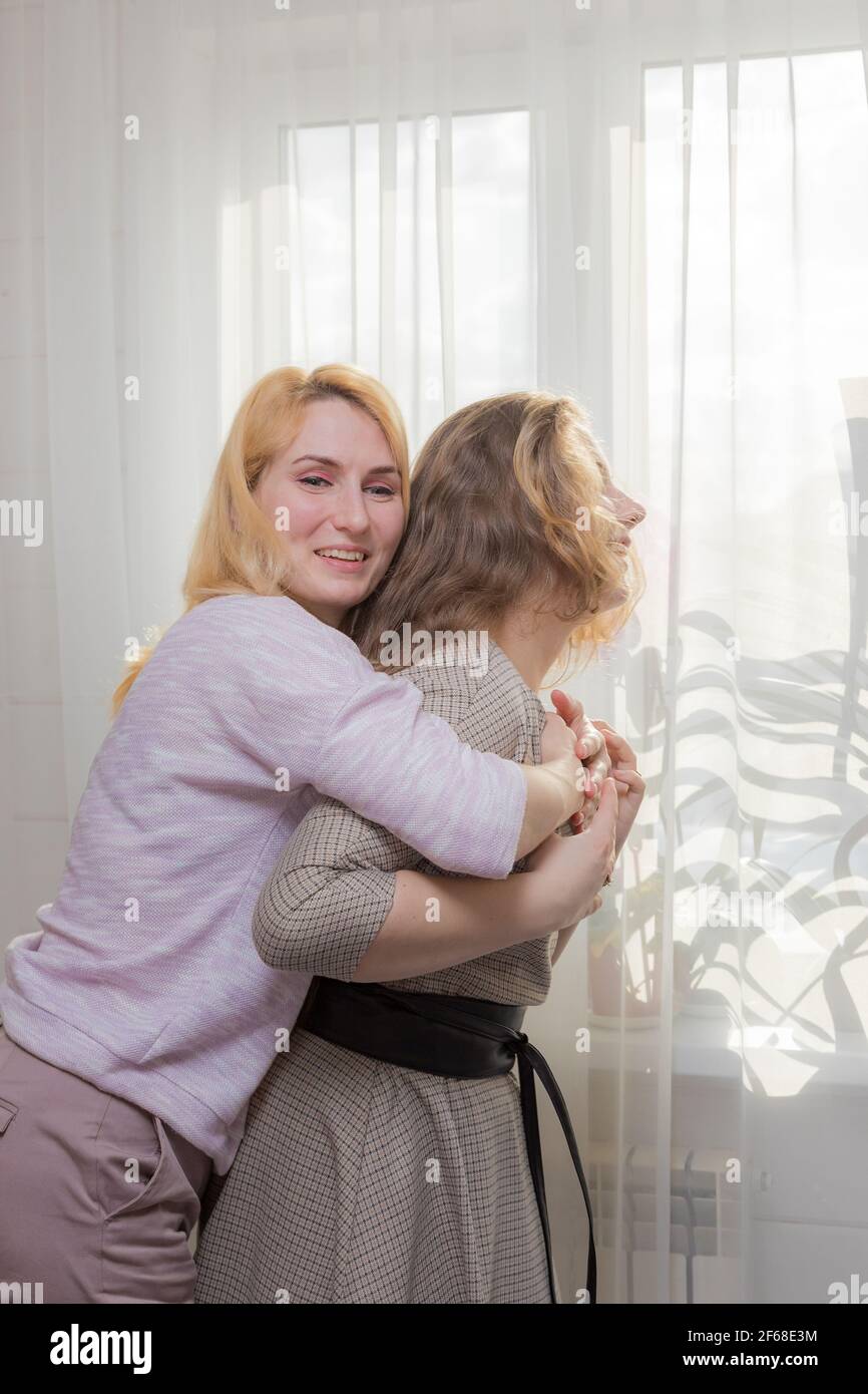 A young girl congratulates her mother on the holiday. Hugs gently and smiles. Stock Photo