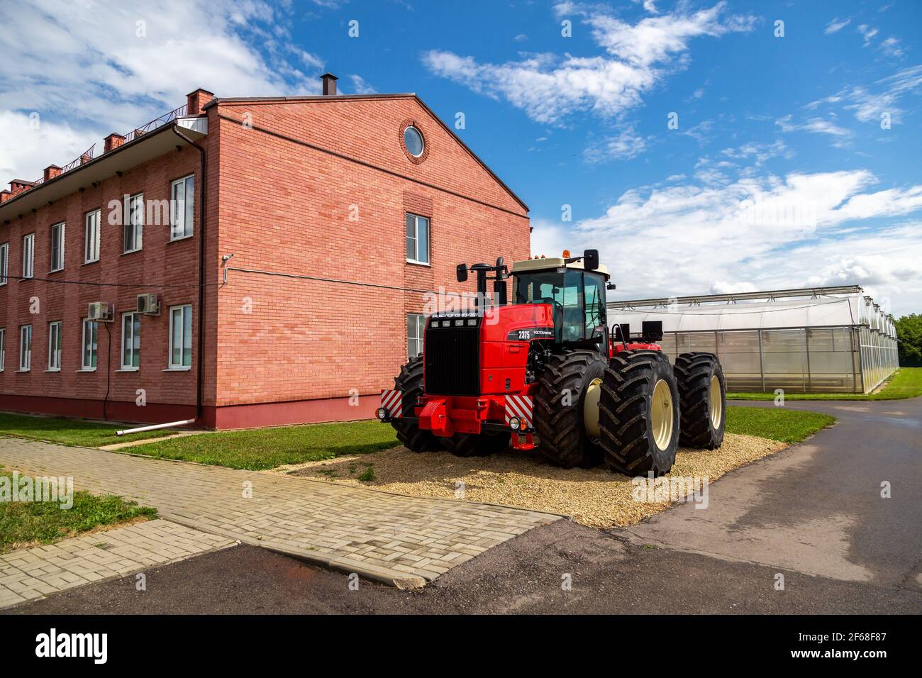 Red collective farm tractor produced by Rostselmash on the territory of the institute's greenhouses  Stock Photo