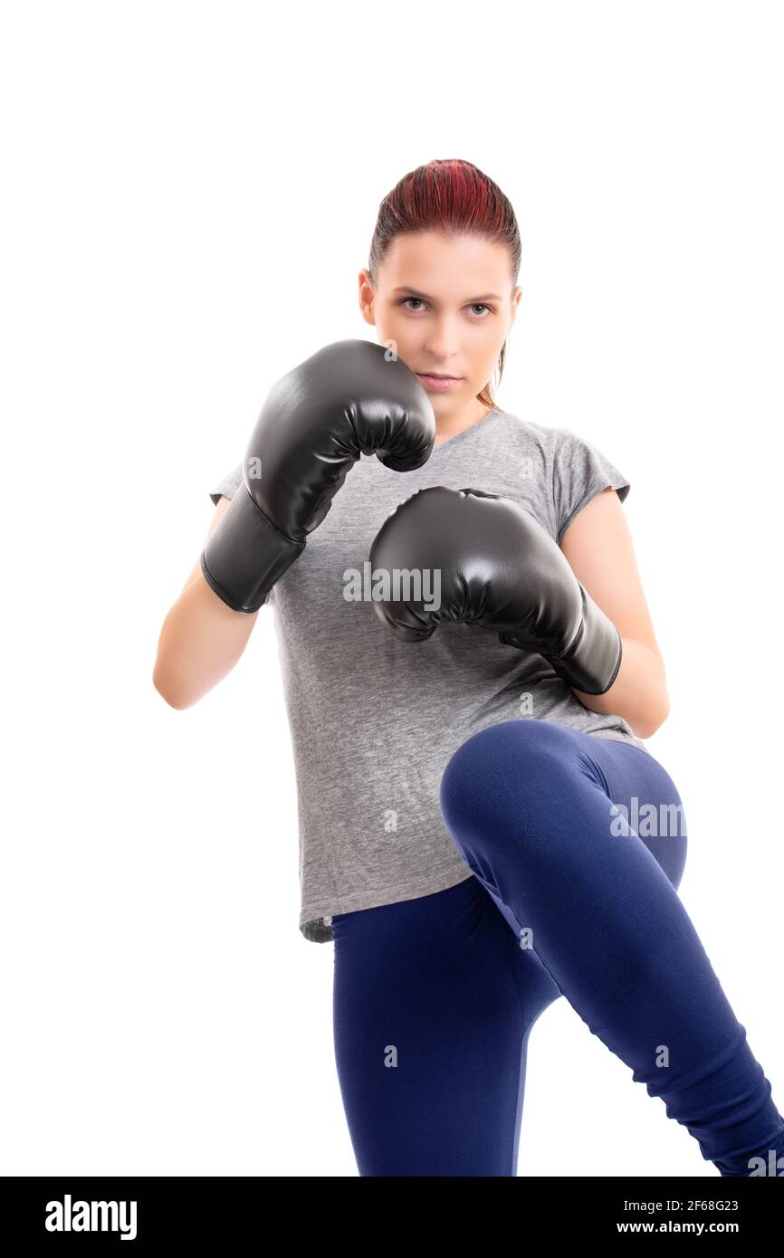 Portrait of a beautiful young serious girl with boxing gloves lifting