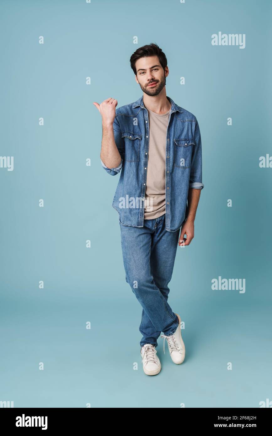 Young handsome guy pointing finger aside at copyspace isolated over blue background Stock Photo