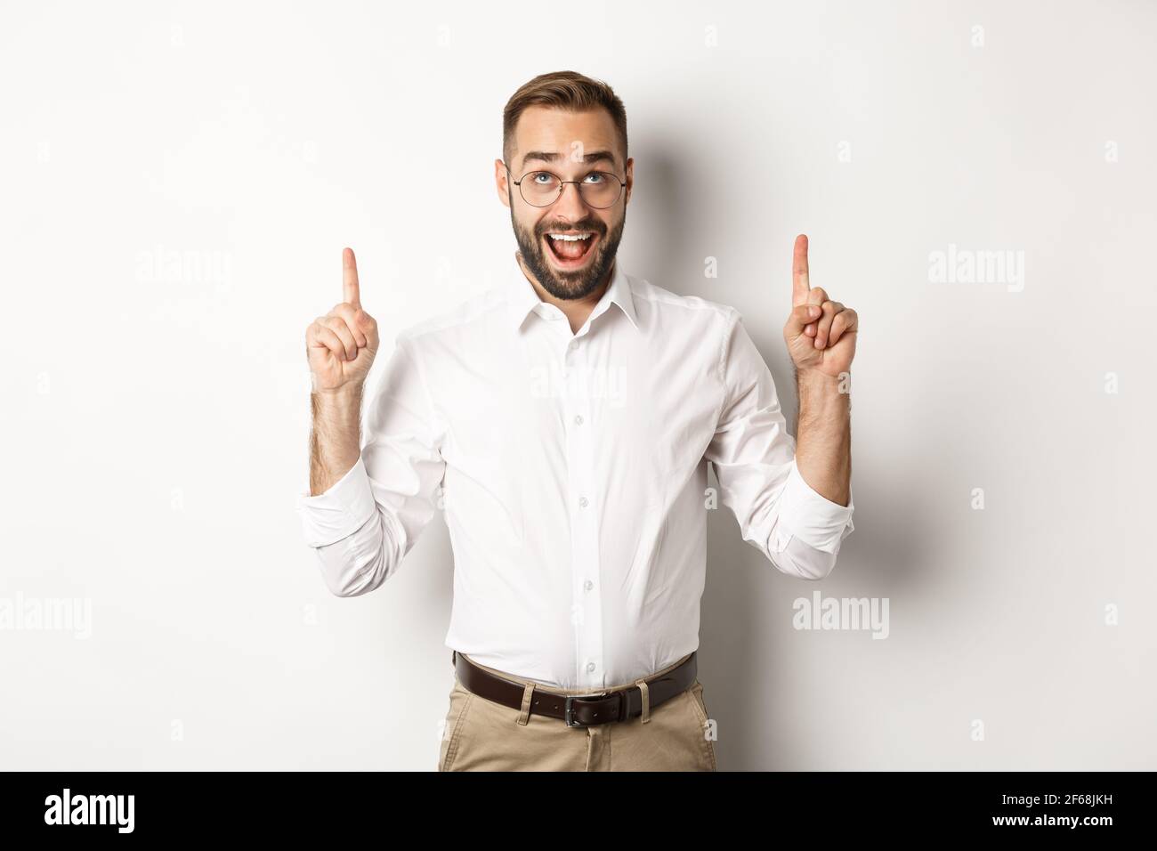 Excited businessman checking out advertisement, pointing and looking up ...