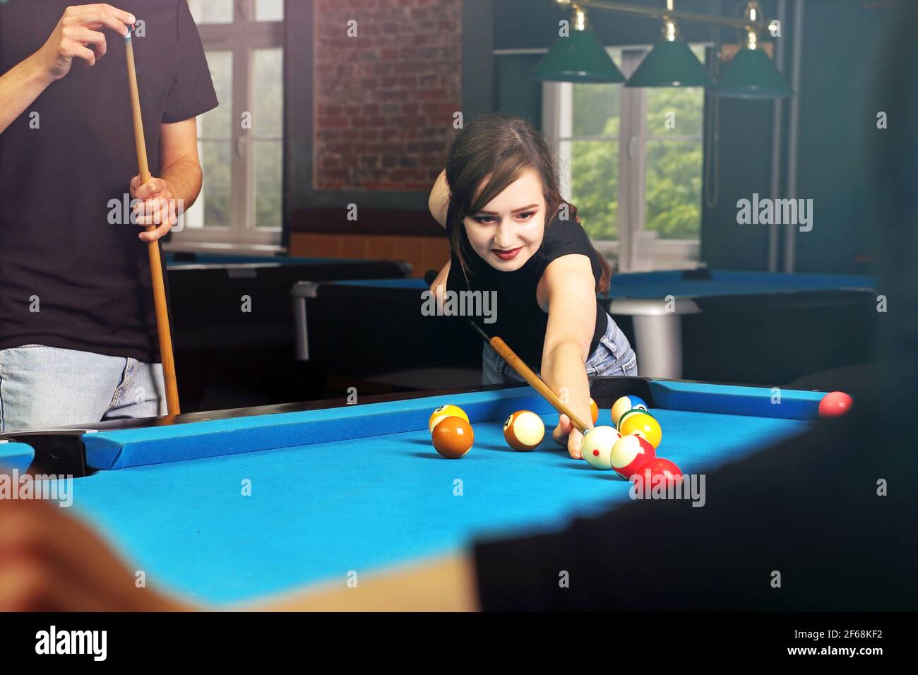 Playing billiards, the player sets the balls on the pool table. Stock Photo