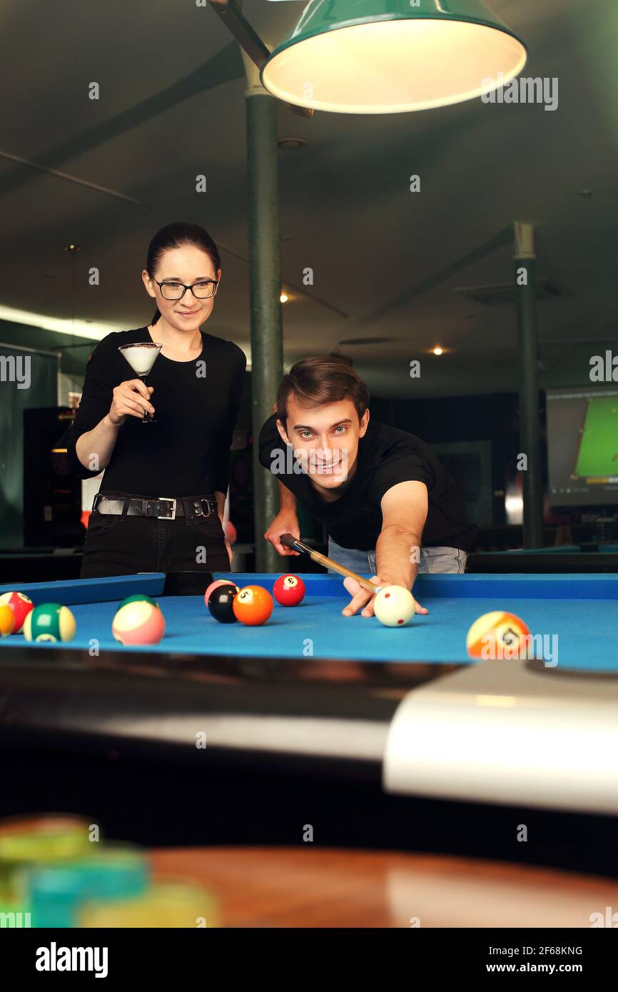 Playing billiards, the player sets the balls on the pool table. Stock Photo