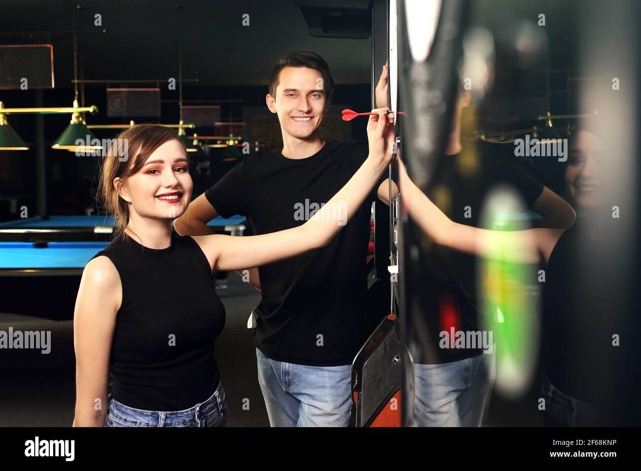 Darts. Young people throw darts at the target. Friendly game in a pub