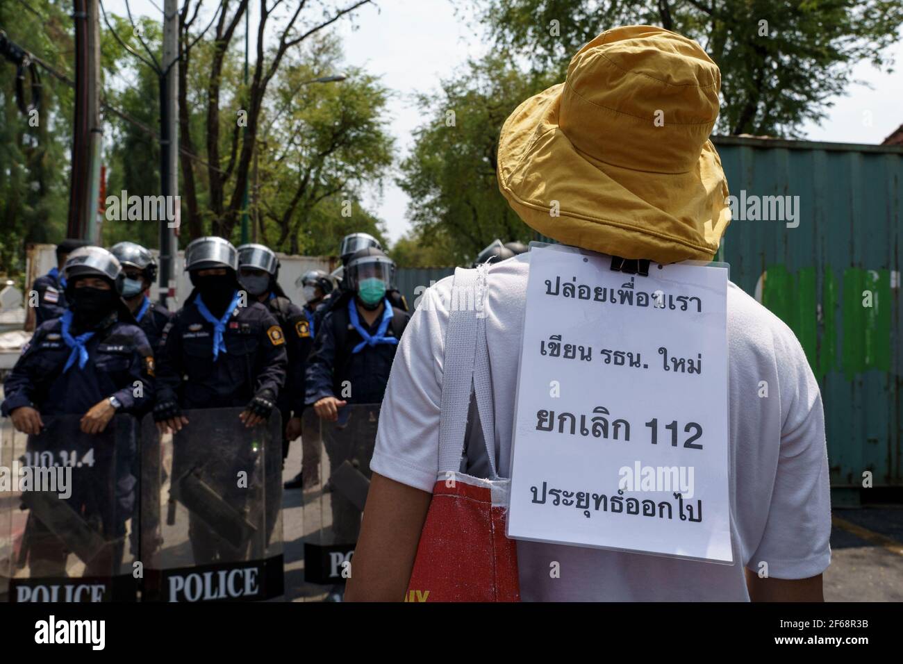 A protestor makes a stand-off with crowd control police during the demonstration.Pro-democracy protestors gathered in front of Thailand's government house to protest after the Thai government forcefully cracked down a peaceful camping protest called 'Thalufah Village' the main ideas of this protest were to demand the release of pro-democracy leaders who are in custody because of the lèse-majesté law aka article 112. Stock Photo