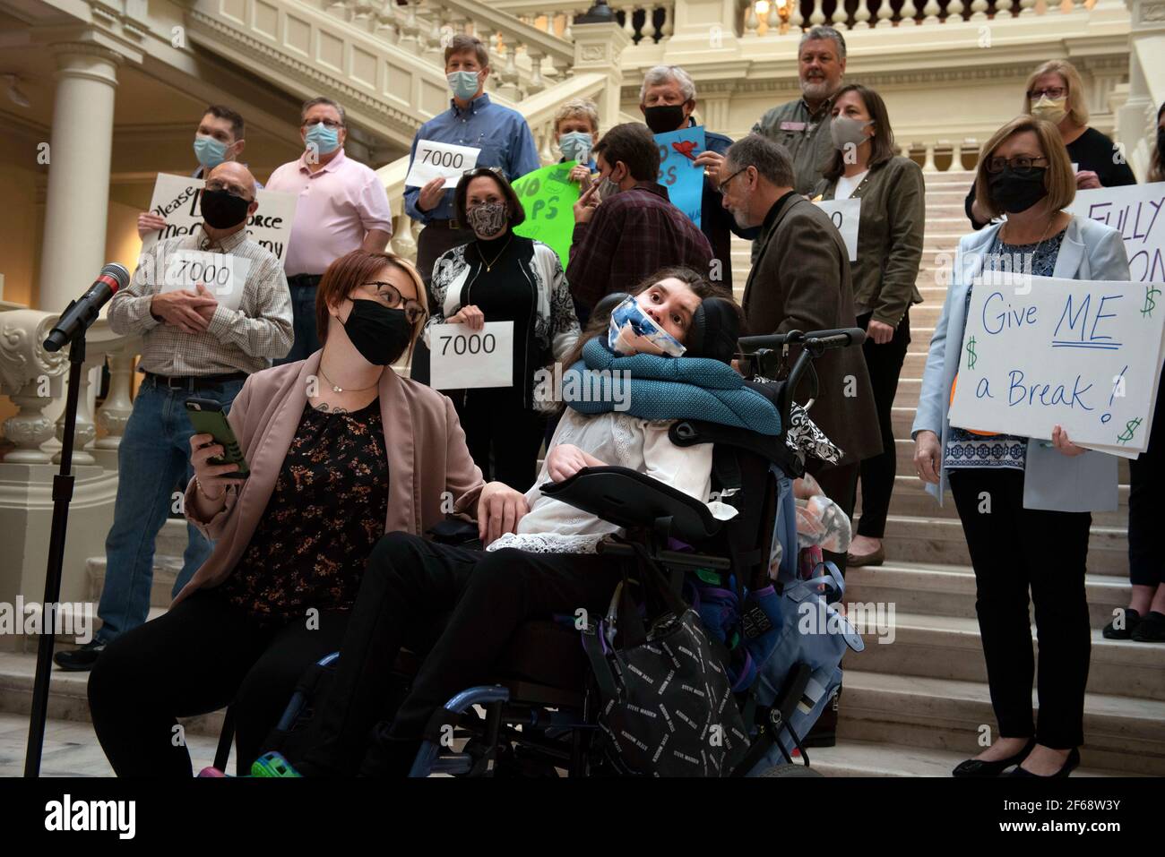 Atlanta, GA, USA. 30th Mar, 2021. Dozens of disability advocates and parents of children with developmental challenges gather for a press conference in GeorgiaÃs statehouse to protest the stateÃs recent budget policy changes that impact 188 medically fragile and vulnerable residents. The new reallocation of funds take effect April 1 and limit the hours available for in-home care. Those cuts increase the possibility of relocation from their homes back into institutionalized care, advocates said. Pictured: Bri James addresses crowd on behalf of her non-verbal sister Callie Moore, one of the 1 Stock Photo